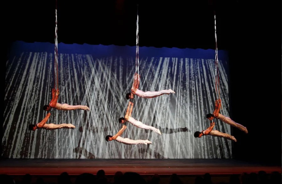 Chinese acrobats performing synchronized aerial straps routine