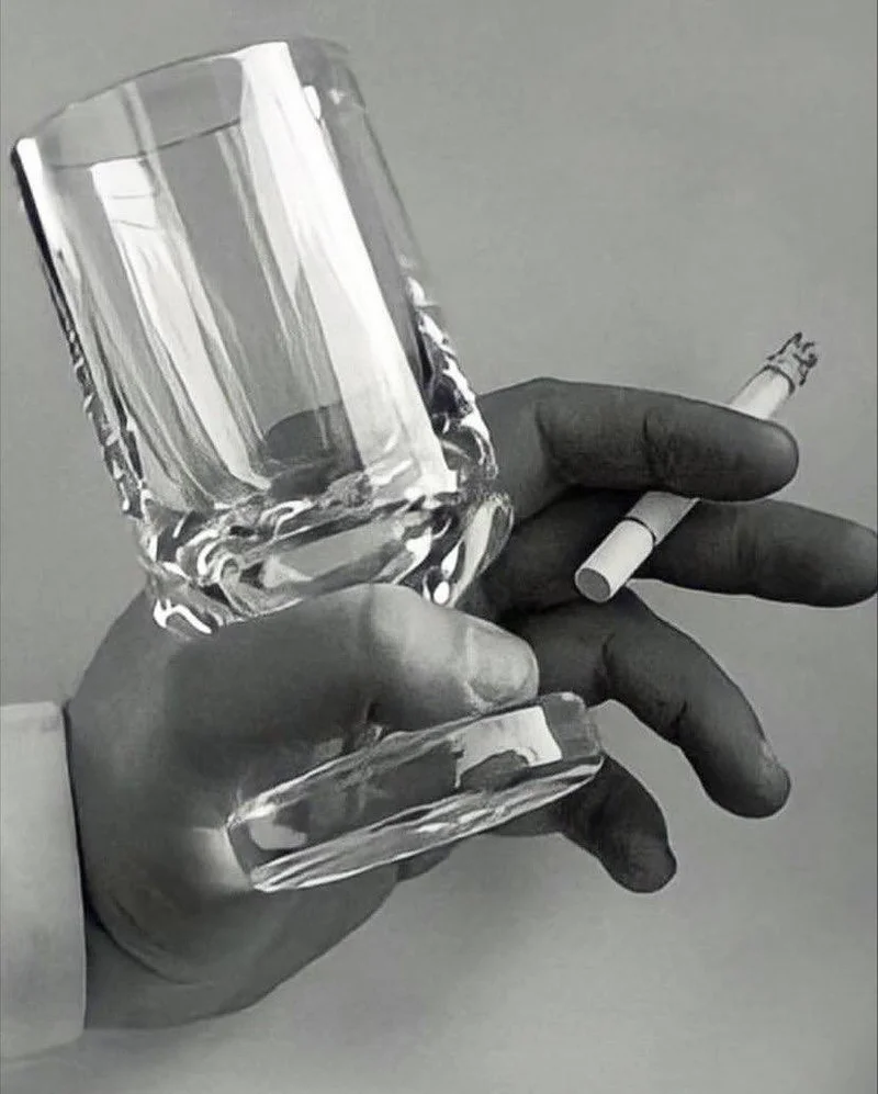 Smoke Glass held in one hand alongside a cigarette, demonstrating the design's function